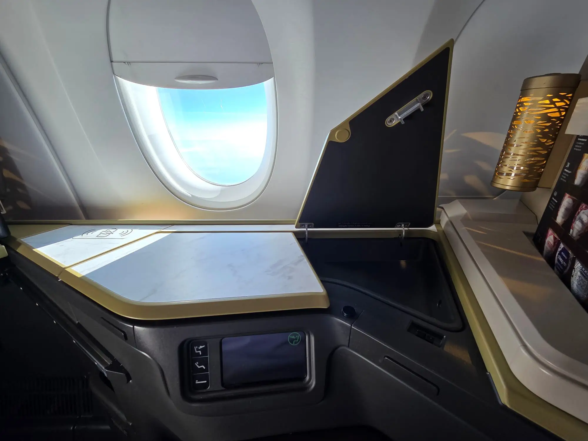 Side table and window beside a business class seat, early morning light