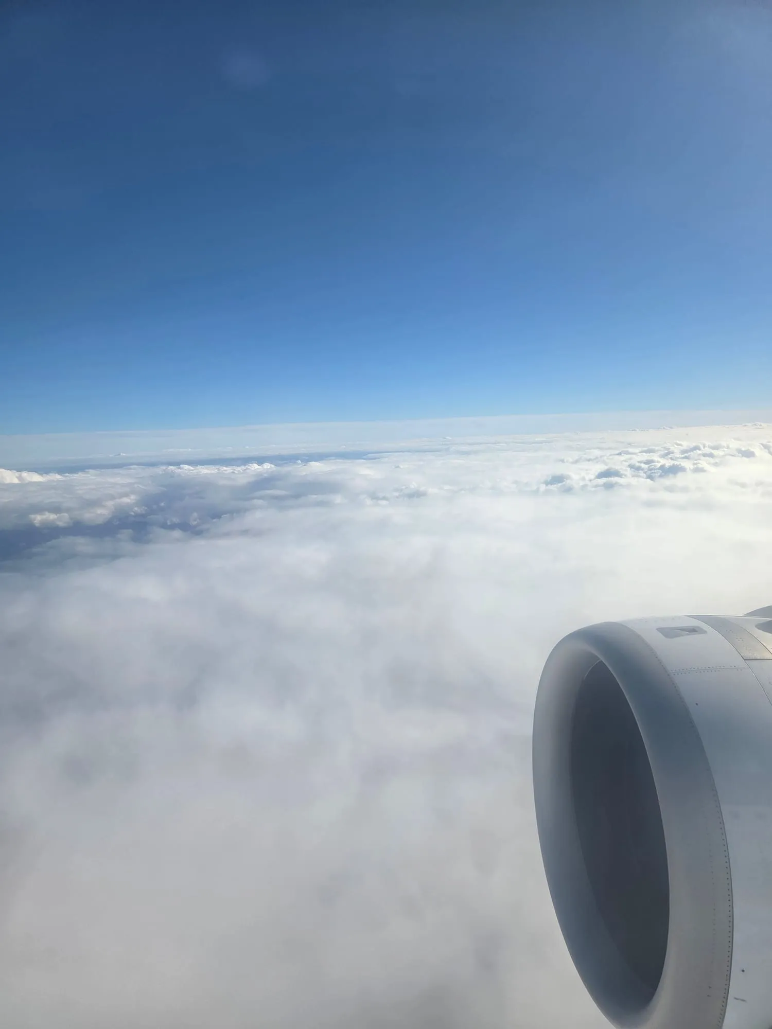 Engine and wing above the clouds after leaving Manchester